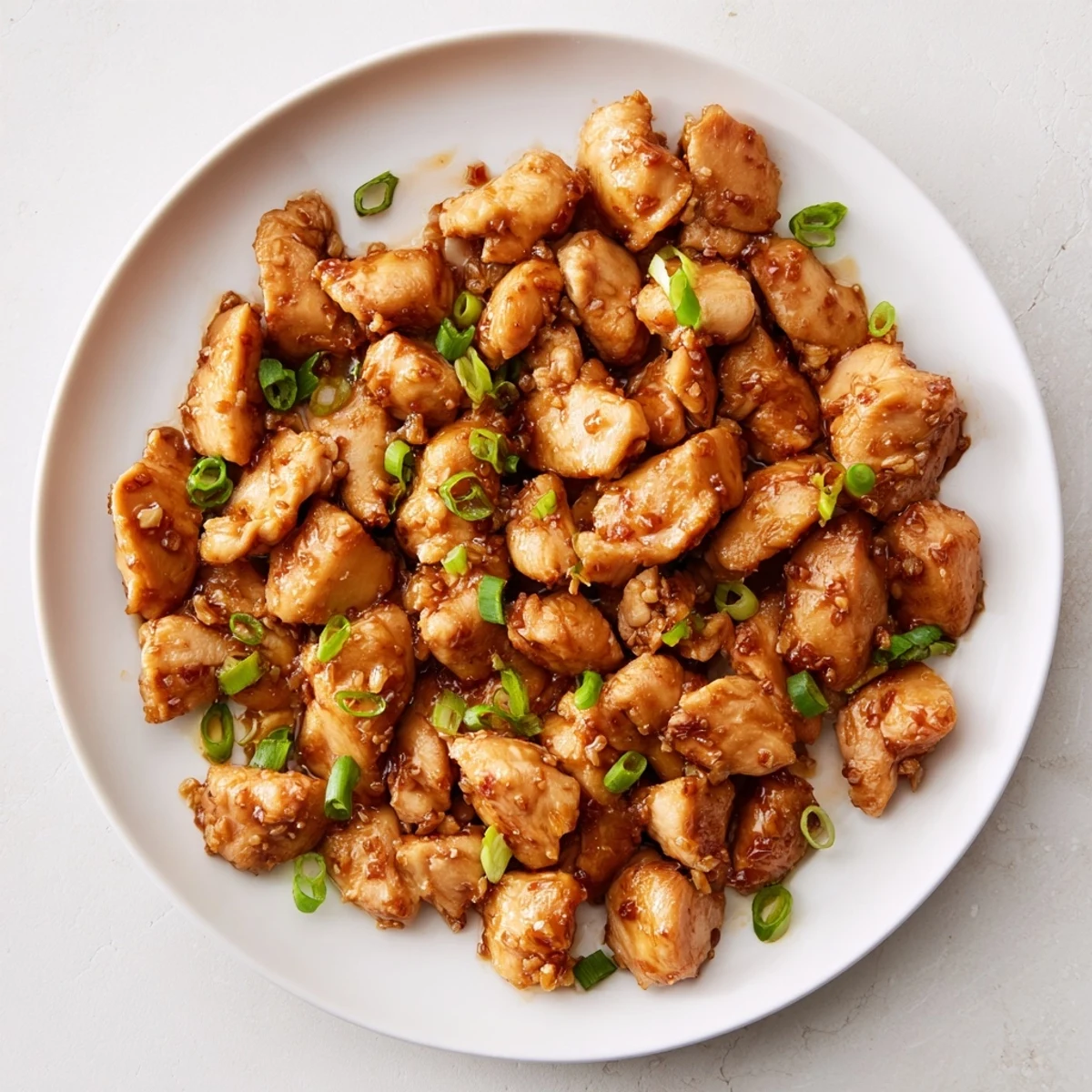 Golden brown Mongolian chicken pieces glistening in thick sweet soy ginger glaze