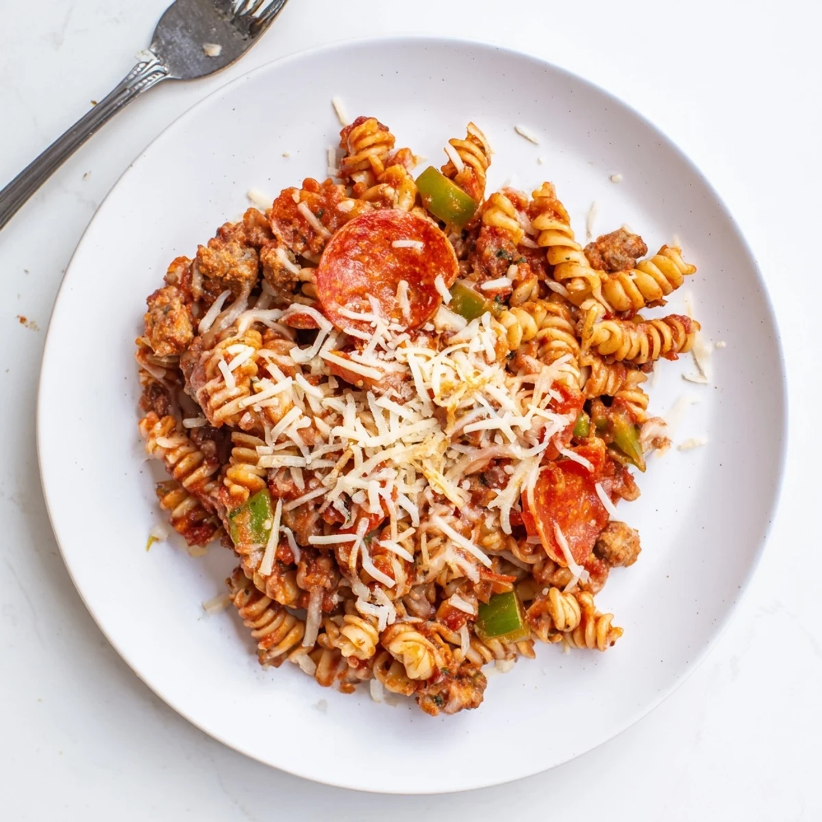 Slow cooker crockpot pizza pasta topped with golden melted cheese, pepperoni, and a sprinkle of Parmesan