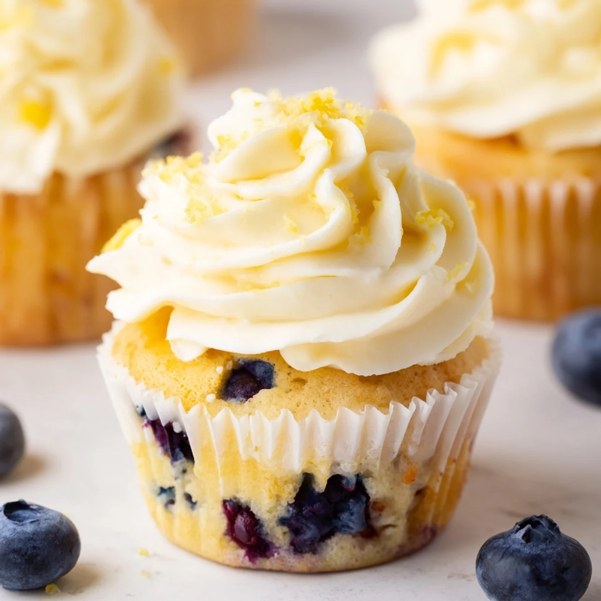Golden baked lemon blueberry cupcakes swirled with smooth lemon cream cheese frosting