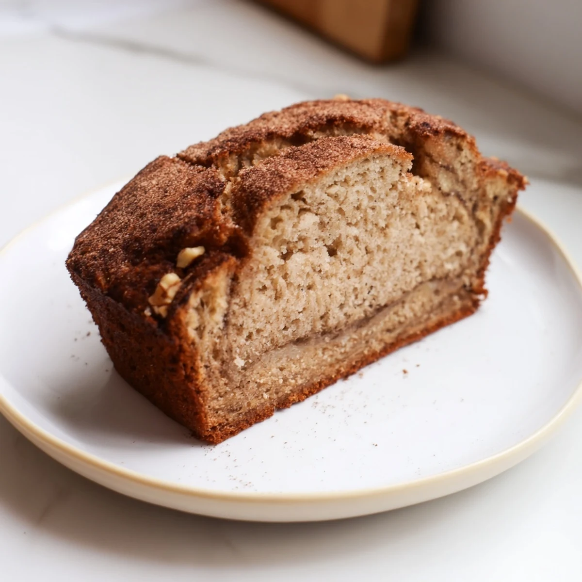 Golden brown carrot cake banana bread loaf speckled with orange grated carrots and warm cinnamon spices