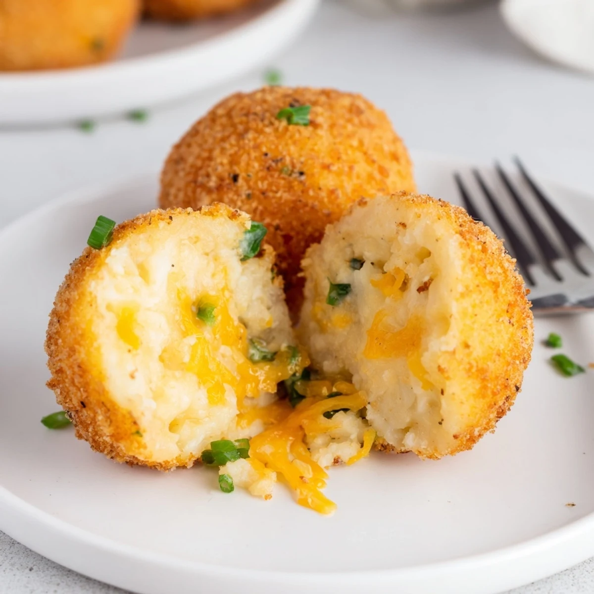 Golden Fried Mashed Potato Balls piled on a plate with ranch dip