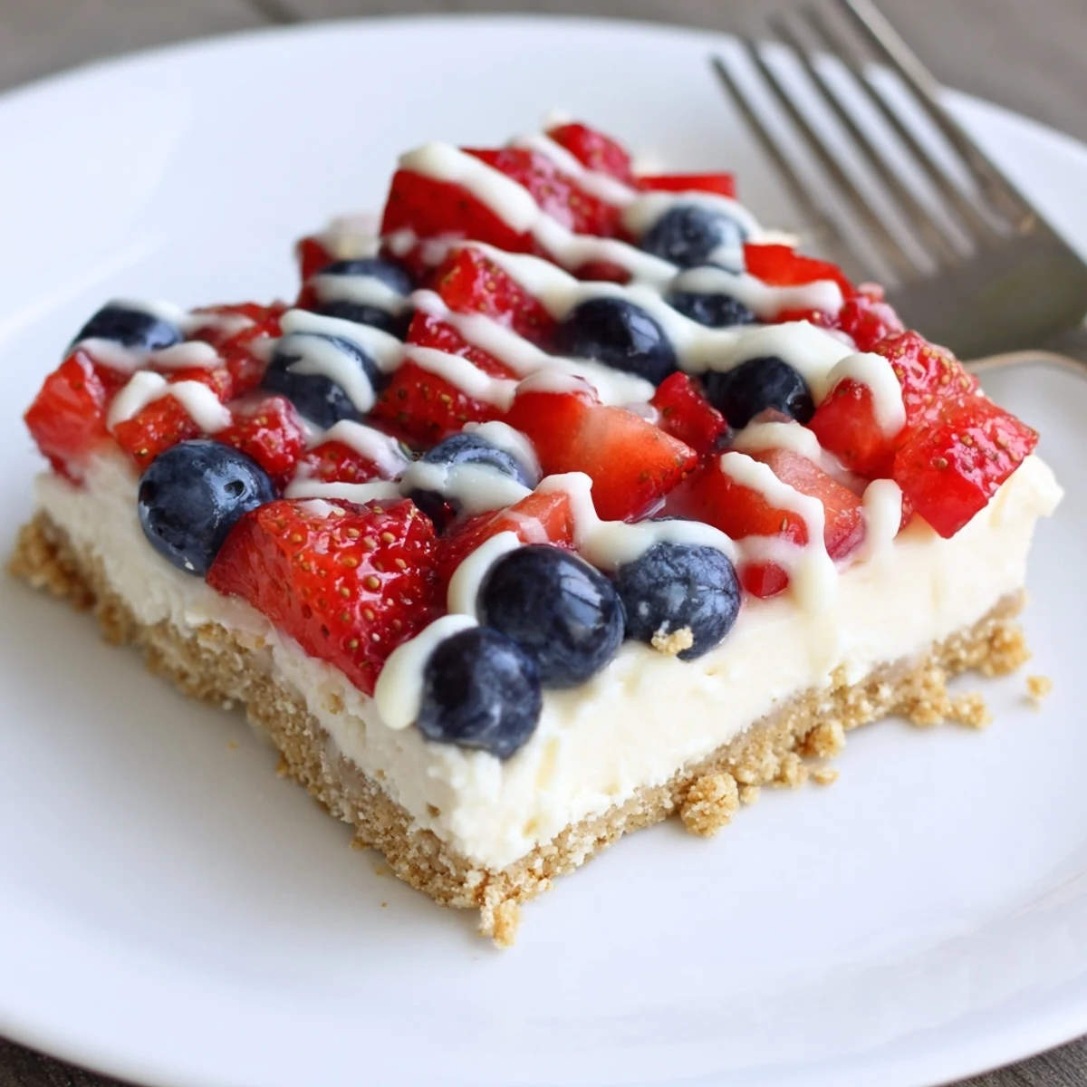 Patriotic Cheesecake Bars with creamy filling, buttery graham crust, fresh berries