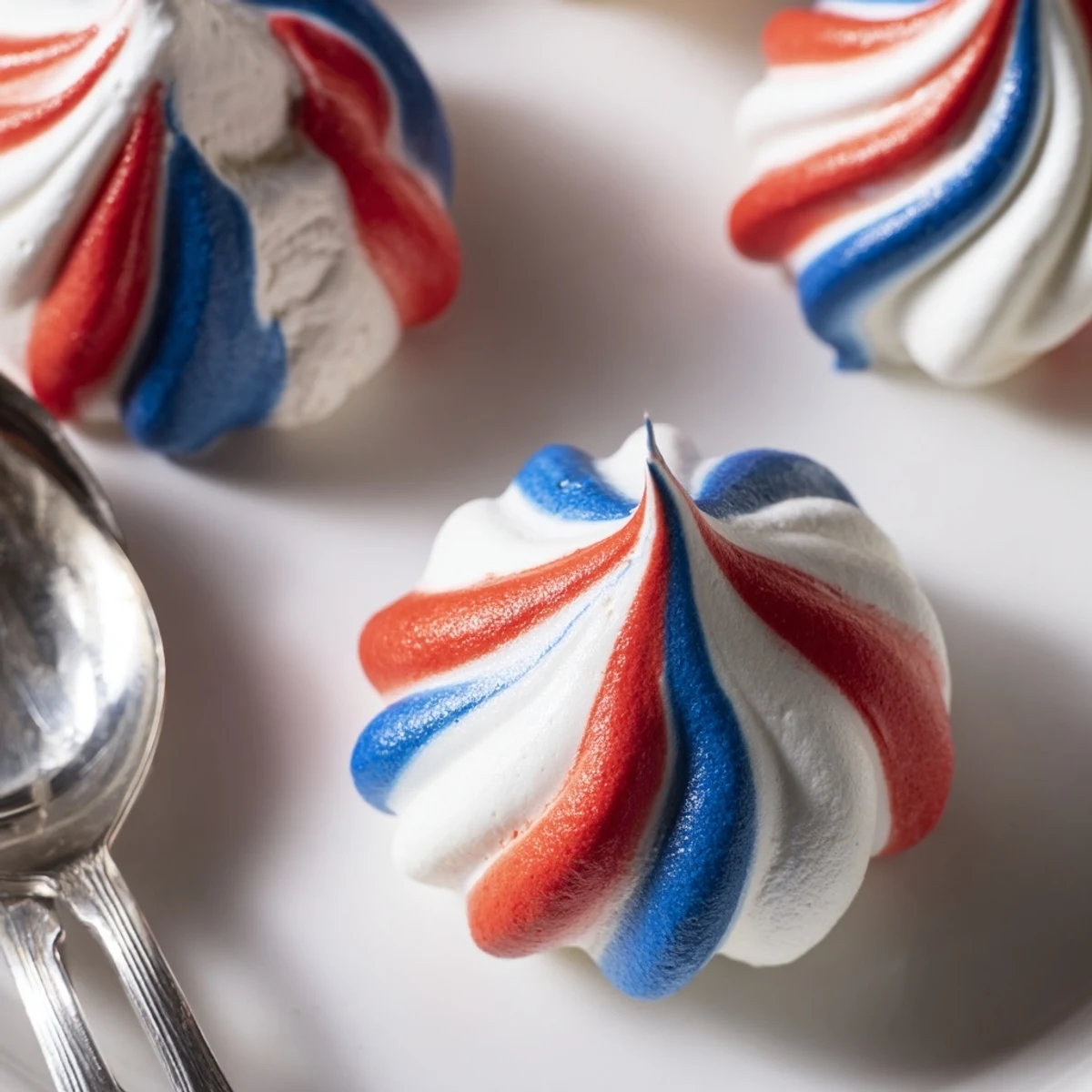 Light and crunchy Patriotic Meringue Kisses piped on parchment, festive party favor