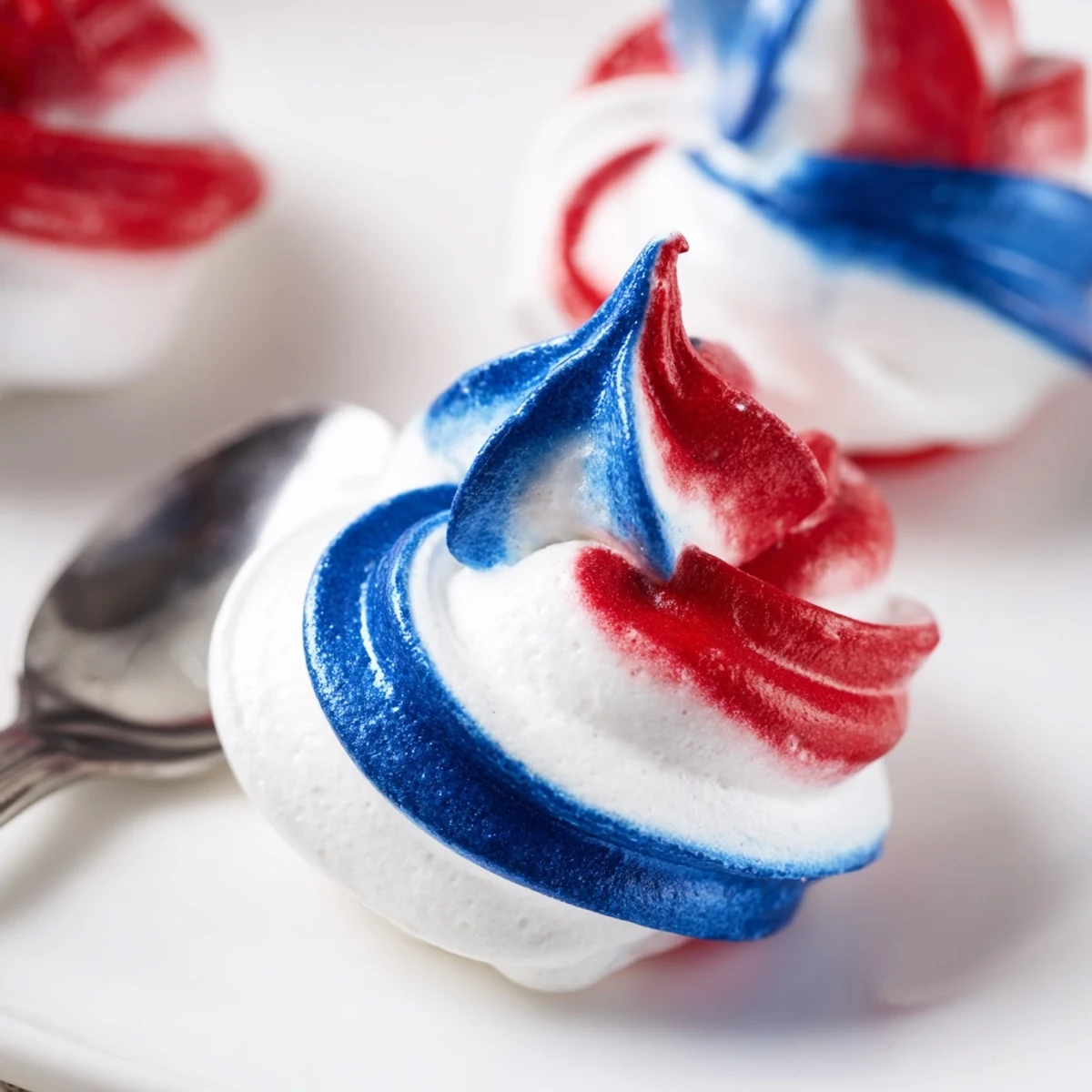 Patriotic Meringue Kisses with crisp red, white, and blue swirls, airy bites
