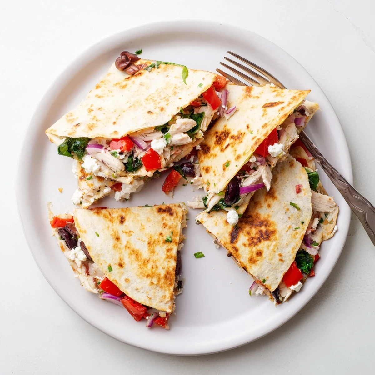 Crispy flour tortilla stuffed with seasoned chicken, roasted peppers, and olives ready for dinner
