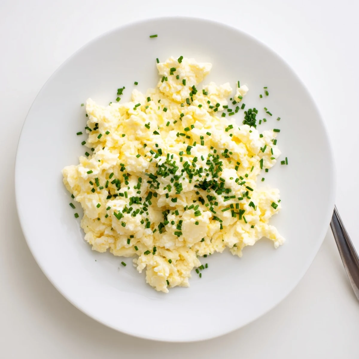 Lightly seasoned Cottage Cheese Scrambled Eggs with Chives, steaming beside sourdough
