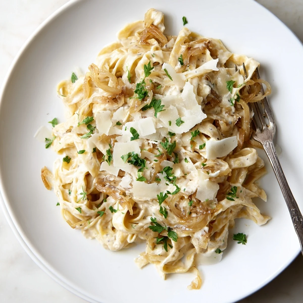 Golden brown caramelized onion cream pasta tossed in a velvety white sauce with fresh parsley