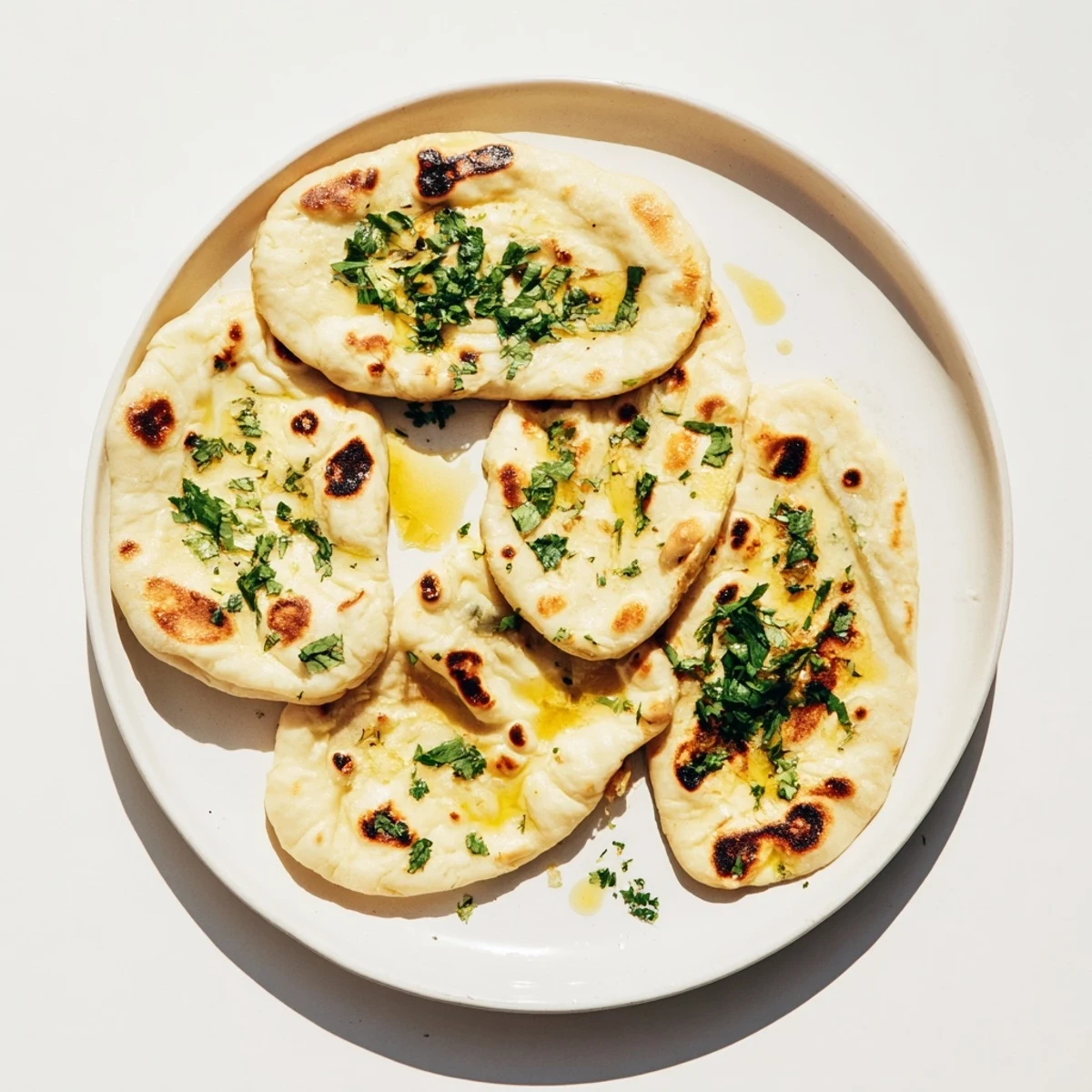 Golden brown sourdough discard naan brushed with melted butter and fresh cilantro