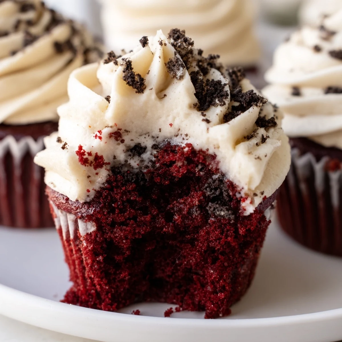 Soft Red Velvet Oreo Cupcakes topped with swirls of tangy cream cheese frosting