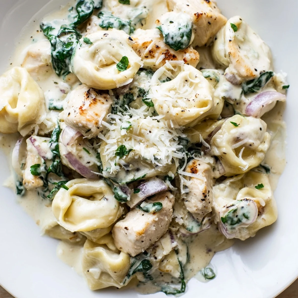 Golden seared chicken and cheese tortellini tossed in a velvety garlic cream sauce