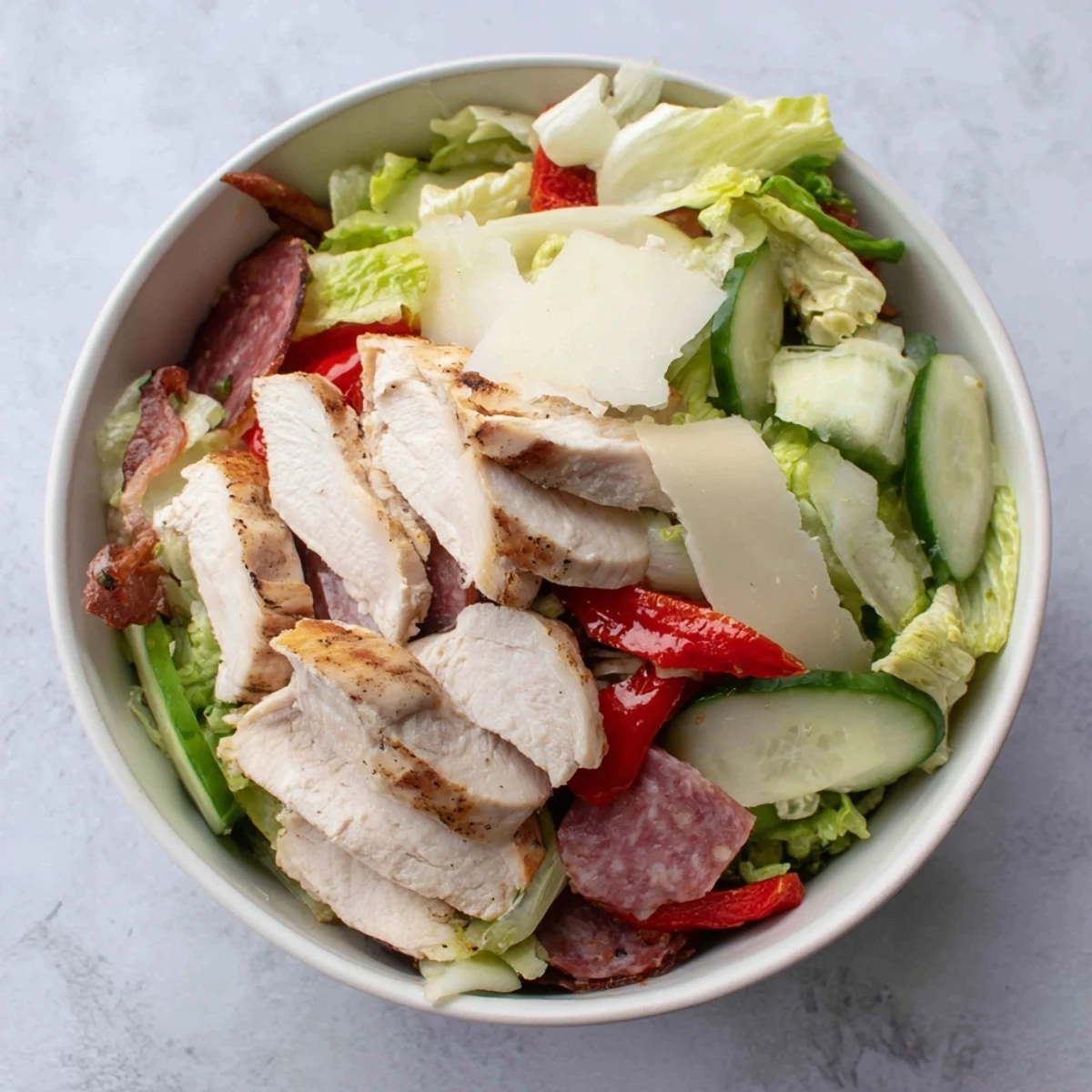 Tender grilled chicken and savory deli meats star in this hearty Italian Grinder Chicken Salad bowl.