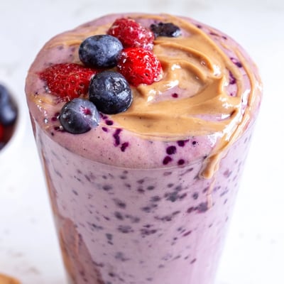 Creamy peanut butter berry smoothie swirled with vibrant berries served in a tall mason jar